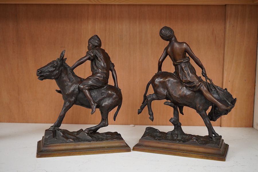 After Paul Aichele (1859-1910), a pair of bronze figures of Arab boys riding donkeys, 23cm